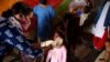 FILE - A health worker administers polio drops to children at a slum in Mumbai, India, June 27, 2021.