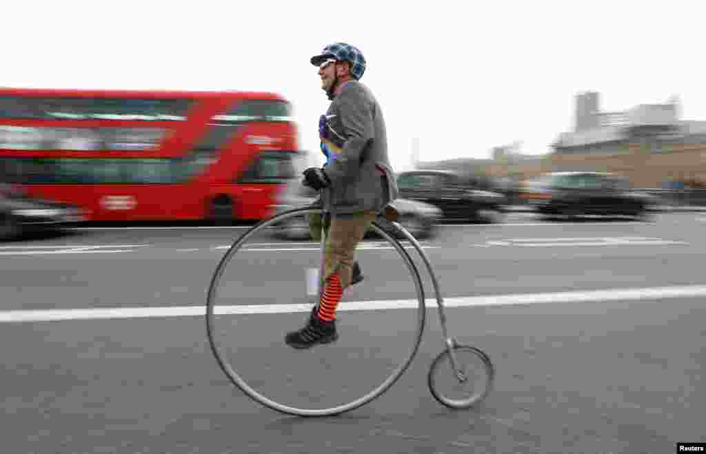 A participant in The Tweed Run cycle ride crosses Westminster Bridge on his Penny Farthing in London, Britain, May 6, 2017.