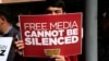 FILE - A protester is seen holding a placard at a rally in support of press freedom near the headquarters of a media company in Istanbul, Wednesday, Oct. 28, 2015.