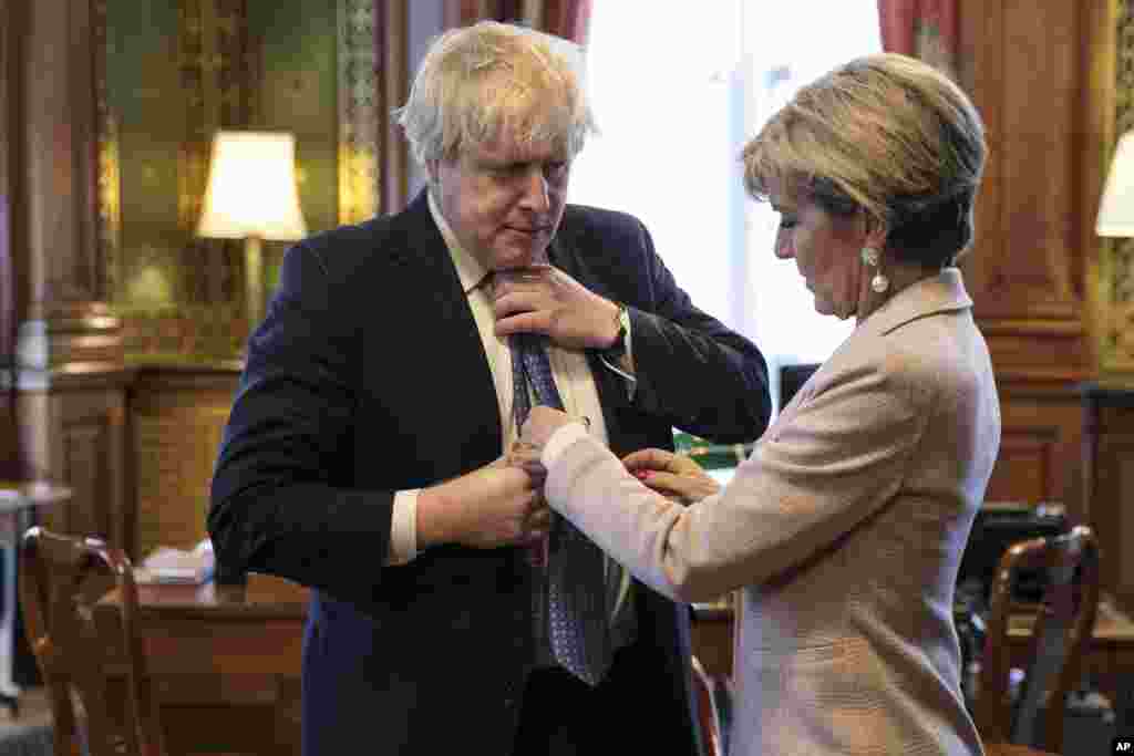 British Foreign Secretary Boris Johnson has his tie straightened by his Australian counterpart Foreign Minister Julie Bishop in his office at the Foreign and Commonwealth Office in London.