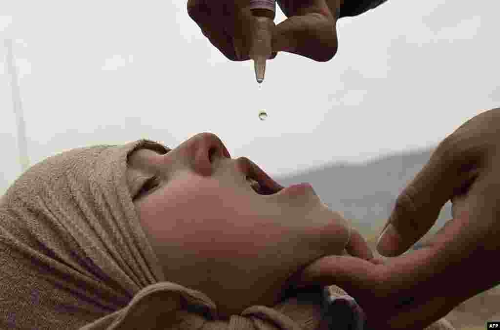 An Afghan health worker administers the polio vaccine to a child during a vaccination campaign in Kabul.