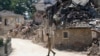 An Italian army soldier walks past rubble in Villa San Lorenzo, near Amatrice, central Italy, Aug. 27, 2016.