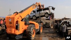 People inspect the scene of a car bomb attack in Baghdad's northern Kazimyah neighborhood, February 8, 2013. 