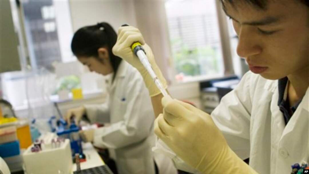 FILE - A lab officer carries out a DNA extraction from cells as part of a process to look for molecular markers containing cancer cells in a patient.