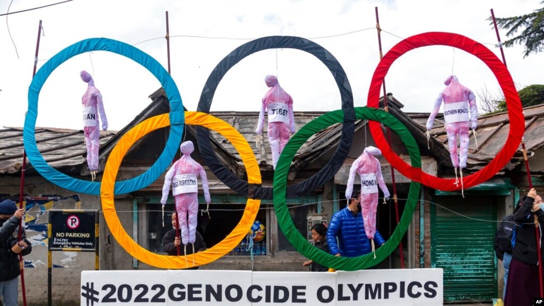 FILE - Exile Tibetans use the Olympic rings as a prop as they protest the holding of the 2022 Winter Olympics in Beijing, in Dharmsala, India, Feb. 3, 2021. 