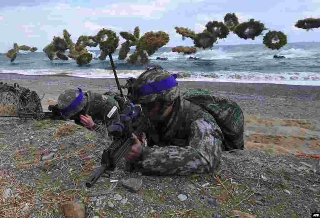 South Korean Marines take position on a beach as amphibious assault vehicles fire smoke shells during a joint landing operation by U.S. and South Korean Marines in the southeastern port of Pohang.