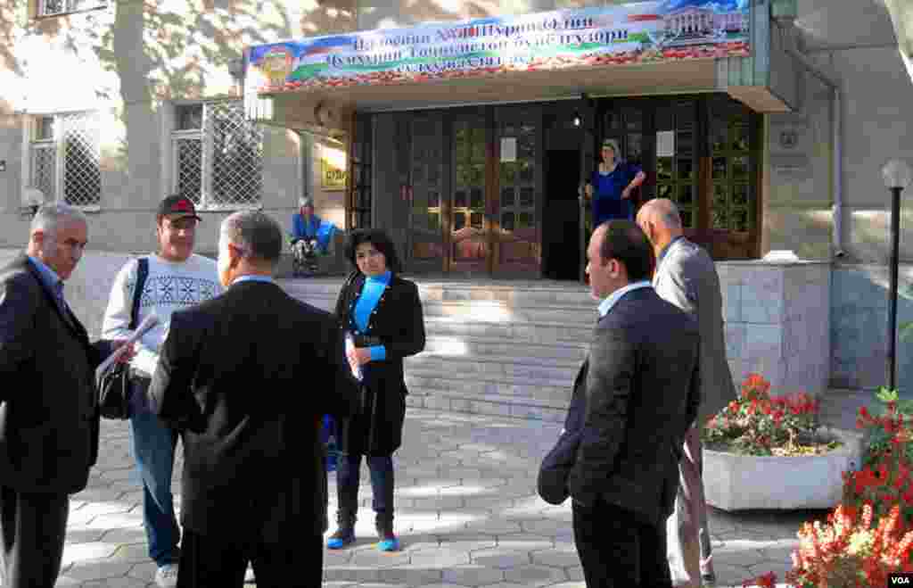 2012-yilning noyabri, Xo'jand shahar sudi binosi oldida da'vogar vazirlik vakili mustaqil jurnalistlar bilan suhbatlashmoqda.