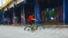Un hombre atraviesa en bicicleta una calle inundada por el huracán Beryl en Playa del Carmen, México, el 5 de julio de 2024.