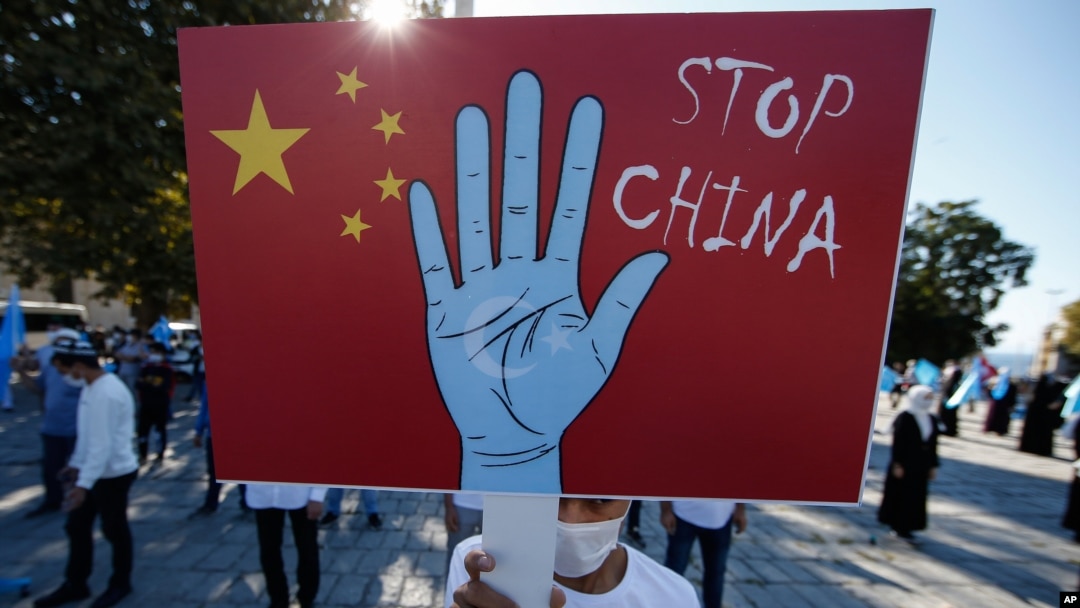 FILE - A protester from the Uighur community living in Turkey holds an anti-China placard during a protest in Istanbul, Oct. 1, 2020, against what they allege is oppression by the Chinese government to Muslim Uighurs in far-western Xinjiang province.