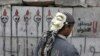 A protester looks at graffiti on cement blocks in front of the presidential palace in Cairo, Egypt, December 16, 2012. 