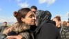 FILE- A relative kisses a Yazidi survivor woman following her release from Islamic State militants in Syria, in Duhok, Iraq, March 2, 2019. 