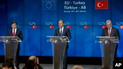 Turkish Prime Minister Ahmet Davutoglu (L), European Council President Donald Tusk (C) and European Commission President Jean-Claude Juncker address a media conference at an EU-Turkey summit in Brussels, Nov. 29, 2015.