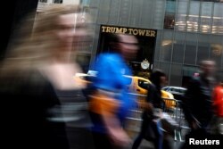 FILE - Pedestrians are seen in a slow shutter speed photograph as they pass Trump Tower on 5th Avenue in New York City, April 26, 2017.