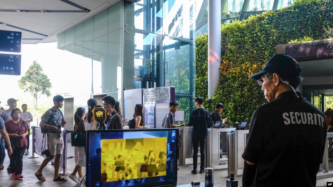 A security officer views a thermal screening monitor as visitors enter Gardens by the Bay nature park, in Singapore, March 14, 2020.