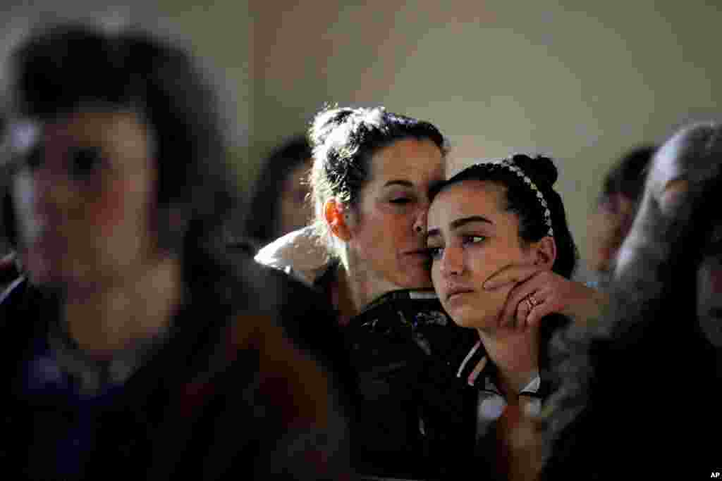 Elizabeth Bogdanoff, left, kisses her daughter Julia, 13, during a prayer service at St John&#39;s Episcopal Church on Dec. 15, 2012 in Newtown, Conn.