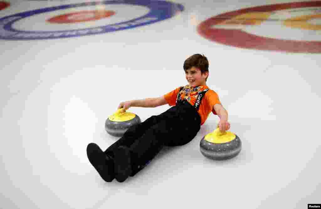 A Yazidi refugee from Kurdistan learns the sport of curling at the Royal Canadian Curling Club during an event hosted by the "Together Project," in Toronto, Canada, March 15, 2017.