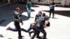 Turkish riot police try to protect a person from a group of people of unknown affiliation who were attacking a rally of pro-Kurdish Peoples' Democracy Party (HDP) in Erzurum, Turkey, June 4, 2015. 
