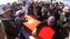 Fehime Aydemir (R), the mother of Turkish officer Metin Aydemir, cries over his coffin during funeral services in his hometown of Erzurum, Turkey, Aug. 19, 2015. Aydemir was one of the three officers killed Tuesday in an operation against Kurdish PKK rebels.
