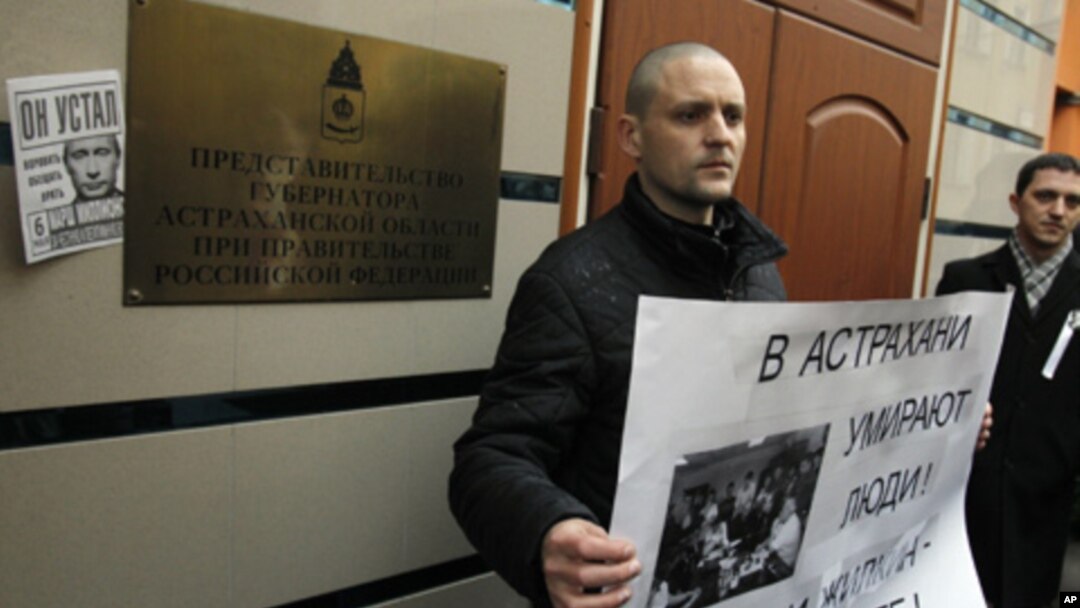 Russian opposition leader Sergei Udaltsov holds a placard during a rally outside the representative offices of the Astrakhan region during a rally in Moscow, April 9, 2012.