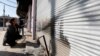 Iraqi volunteers paint over signs and writing of Islamic State militants, in Qaraqosh, Iraq, Feb. 7, 2017. 