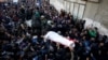 Mourners and Palestinian Hamas members carry the body of their comrade, who was killed in an Israeli airstrike, during his funeral in Gaza City December 9, 2017. 