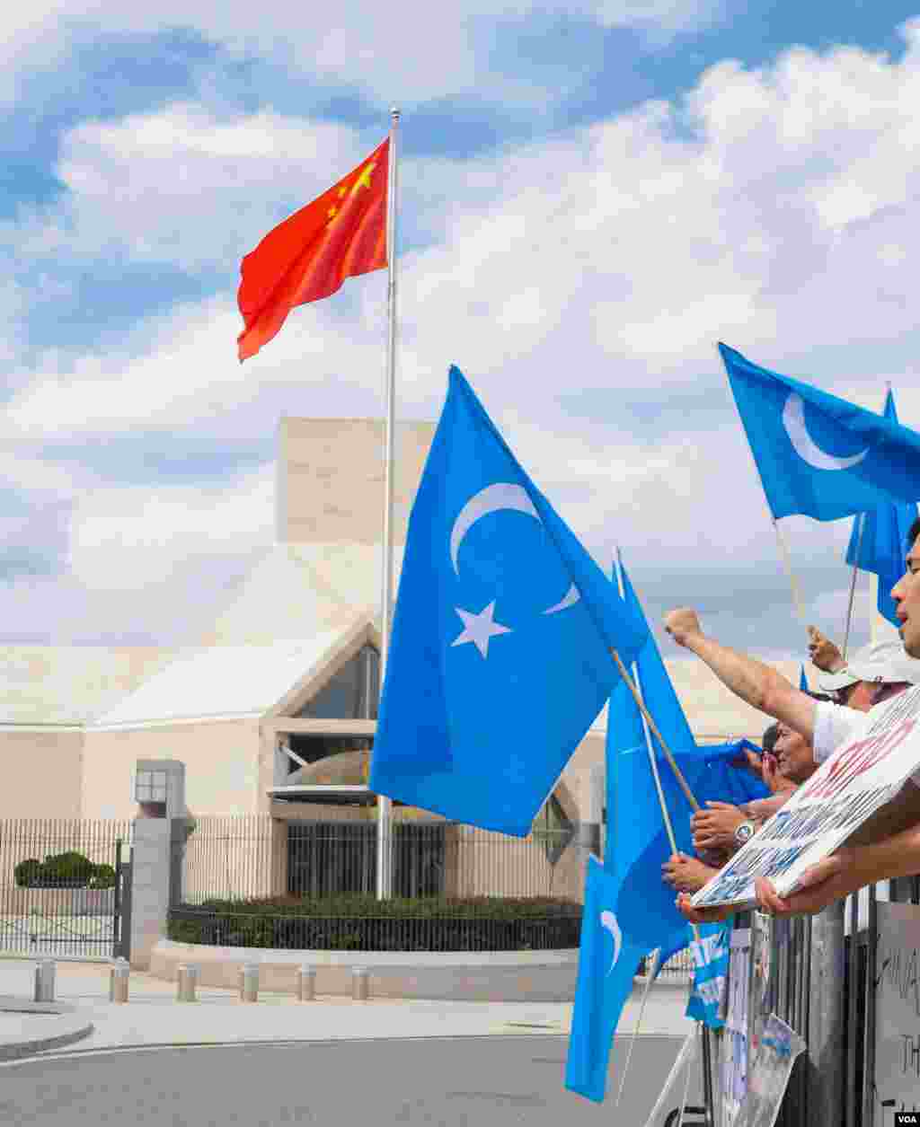 Uyg'urlar Sharqiy Turkiston bayroqlarini ko'tarib, Xitoy elchixonasi qarshisida bu davlatning uyg'urlarga qarshi siyosatini qoralab, namoyish qilmoqda, Vashington, 3-avgust, 2014-yil. Odil Ruzaliev surati
