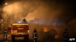 Zjarrëfikësit përpiqen të shuajnë një automjet në flakë në Floriac, në periferit të qytetit të Bordosë. Francë, 29 qershor, 2023.