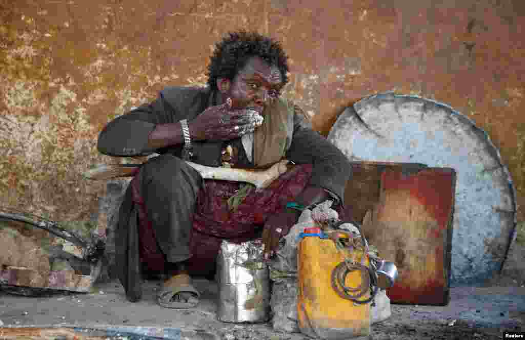 An internally displaced man eats a maize meal from the United Nations World Food Programme (WFP) feeding program at the Sorrdo camp in Hodan district of Somalia's capital Mogadishu.