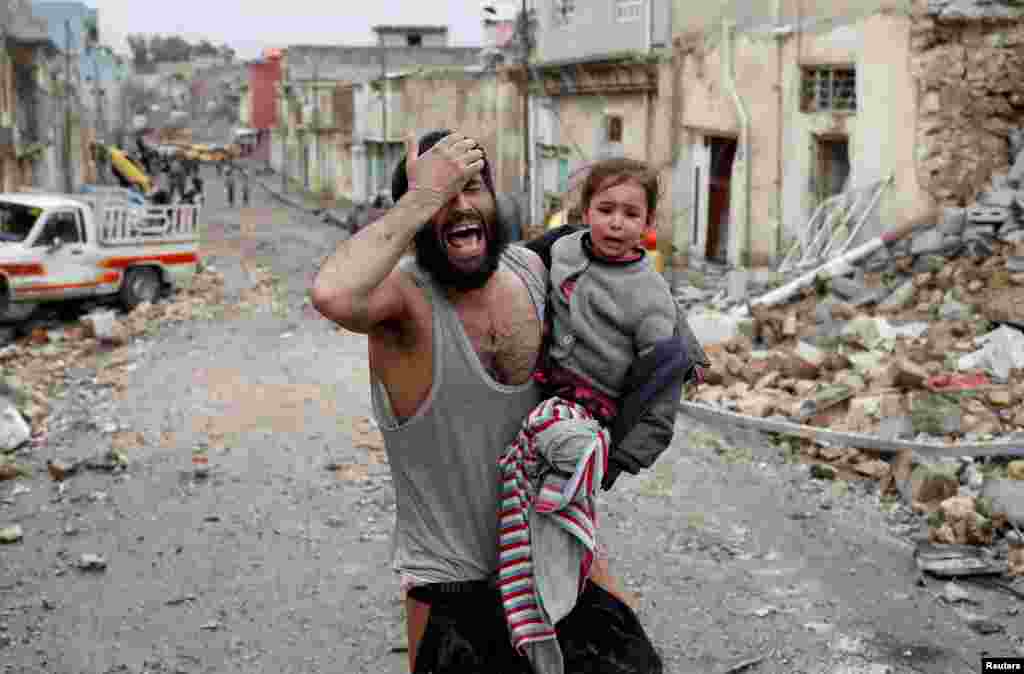 A man and his daughter cry as they flee Islamic State-controlled part of Mosul toward Iraqi special forces soldiers during a battle in Mosul, March 4, 2017.