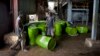 FILE - Workers are seen pushing barrels of vegetable oil.