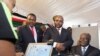 Kenyan President Mwai Kibaki (R) registers as a voter before launching the nationwide, one-month biometric voter registration (BVR) exercise in the capital Nairobi, November 19, 2012, targeting over 18 million voters ahead of the March 4 General Election.
