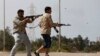 FILE - Fighters from Misrata fire weapons at Islamic State militants near the coastal city of Sirte, Libya, March 15, 2015. 