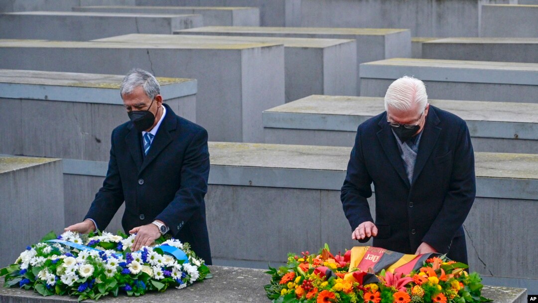 German President Frank-Walter Steinmeier, right, and the Speaker of Israel's Parliament Mickey Levy arrange wreaths on one of the concrete slabs of Berlin's Holocaust Memorial, Jan. 27, 2022, marking International Holocaust Remembrance Day.