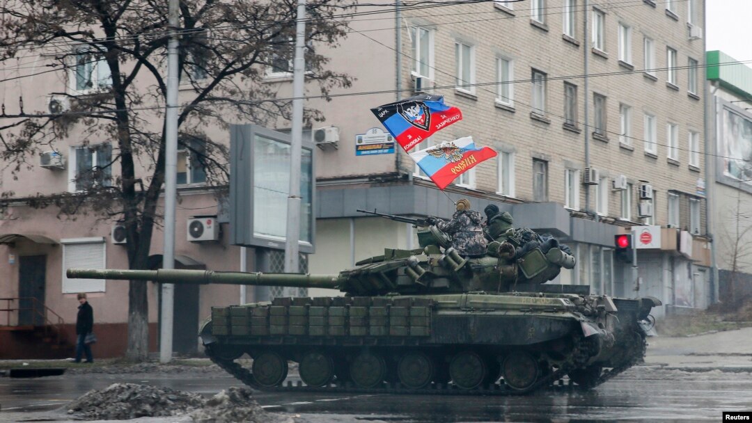 FILE - Pro-Russian separatists ride on a tank in Donetsk, eastern Ukraine, Feb. 1, 2015.
