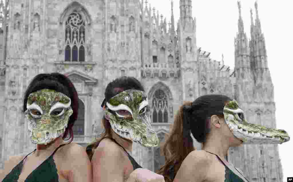 PETA (People for the Ethical Treatment of Animals) activists wear crocodile masks during a demonstration against the use of crocodile skins ahead of Milan's Fashion Week, in Milan's Duomo Square, Italy.