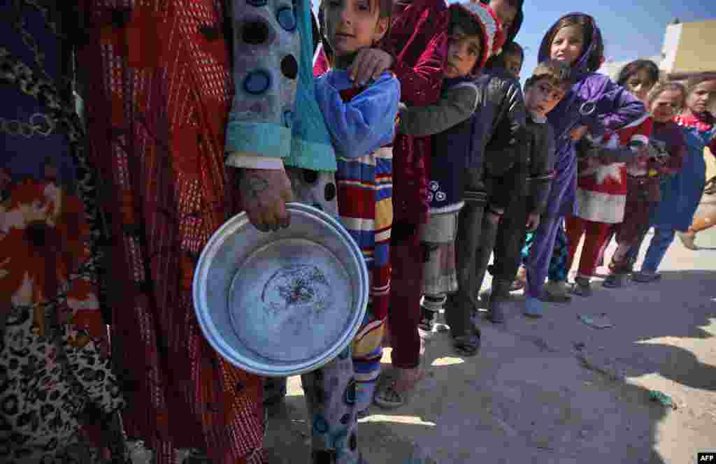 Displaced Iraqi children stand in line to receive food rations in Mosul's western Tal al-Rumman neighborhood, during an offensive to retake the western parts of the city from the jihadists.