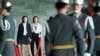 Two Chinese university students from Beijing watch Oct. 26 as military guards at Taipei's Sun Yat-sen Memorial Hall exchange their hour-long shift. The two were among a 14-member delegation offering a donation to the local Chinan University.