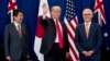 President Donald Trump, accompanied by Japanese Prime Minister Shinzo Abe, left, and Australian Prime Minister Malcolm Turnbull, right, waves to reporters at a meeting during the ASEAN Summit at the Sofitel Philippine Plaza, Monday, Nov. 13, 2017, in Mani