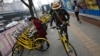 FILE - In this March 21, 2017 photo, commuters use bicycles from bike-sharing company Ofo placed on the sidewalk in Beijing, China. Using shared bikes, thousands of university students rode overnight from Zhengzhou, the largest city in Henan province, to Kaifeng.
