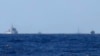FILE - Chinese ships are seen on the horizon guarding the Haiyang Shiyou 981, known in Vietnam as HD-981, oil rig (2nd R) in the South China Sea, July 15, 2014.