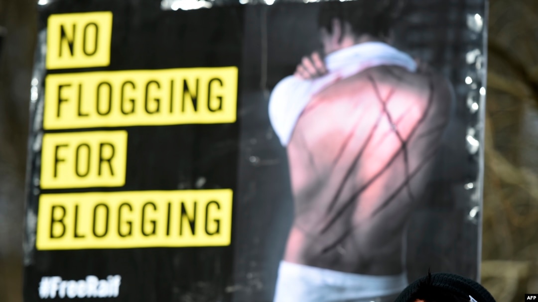 FILE - Amnesty International activists protest with a placard reading 'No flogging for blogging' against the flogging punishment of Saudi blogger Raif Badawi, in front of Saudi Arabia's embassy in Berlin, Germany, Jan. 29, 2015.