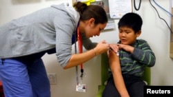 FILE - A boy gets a flu shot at a health care clinic in Boston, Massachusetts, Jan. 12, 2013.
