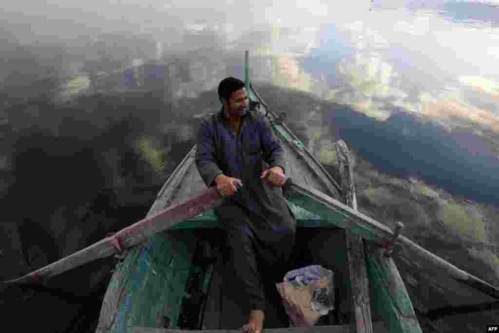 A fisherman sits in his boat in the Egyptian Nile Delta province of al-Minufiyah, near the town of Ashmun.