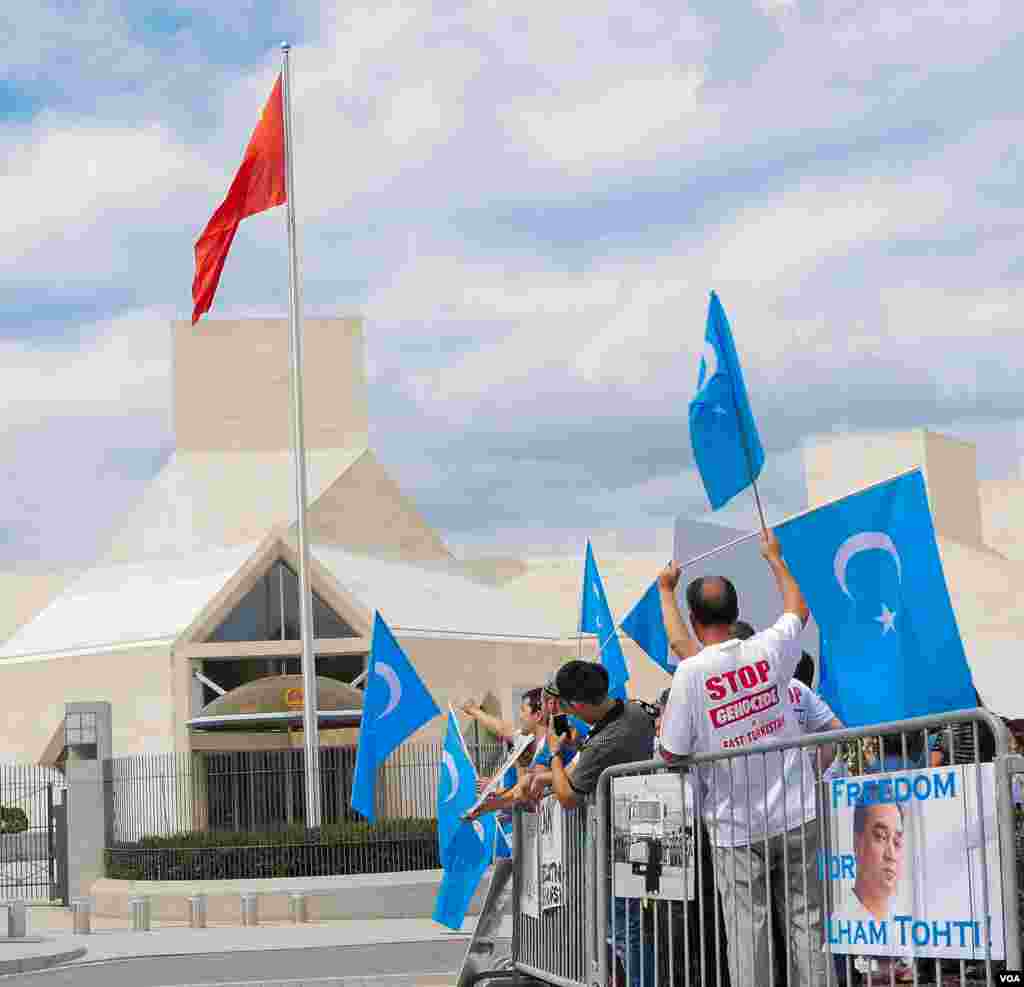 Uyg'urlar Sharqiy Turkiston bayroqlarini ko'tarib, Xitoy elchixonasi qarshisida bu davlatning uyg'urlarga qarshi siyosatini qoralab, namoyish qilmoqda, Vashington, 3-avgust, 2014-yil. Odil Ruzaliev surati