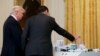 FILE - AT&T CEO Randall Stephenson, right, demonstrates 5G technology to President Donald Trump during the "American Leadership in Emerging Technology" event in the East Room of the White House, June 22, 2017, in Washington. 