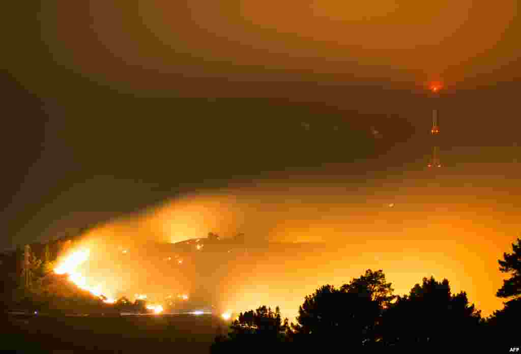 This handout picture provided by Oliver Watson of http://ownzproductions.wixsite.com/home shows flames from the wildfire on Worsleys Road in Christchurch, New Zealand, before sunrise.