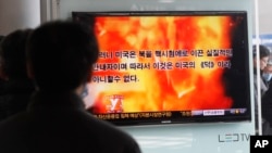 People watch a television program showing a propaganda video released by North Korea at Seoul Railway Station in Seoul, South Korea, February 20, 2013. 
