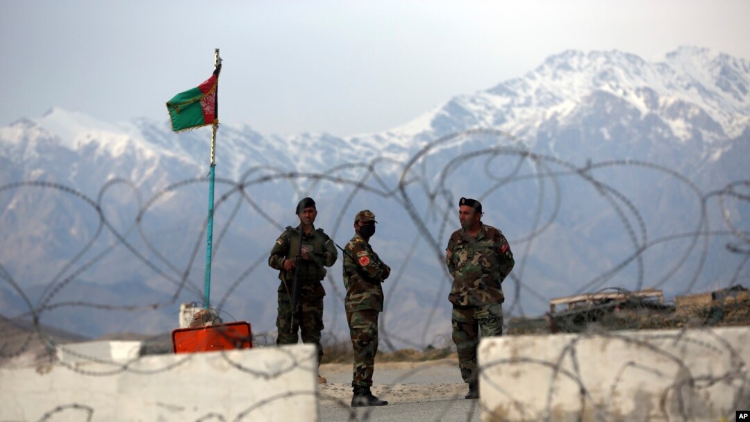 FILE - Afghan National Army soldiers stand guard at a checkpoint near the Bagram base in northern Kabul, Afghanistan, April 8, 2020.