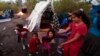 Simona (R), a 11 year-old Roma schoolgirl who has been living in France for 6 years, plays with children near shelters at an illegal camp on the banks of the Var River in Nice, southeastern France, Nov. 6, 2013.