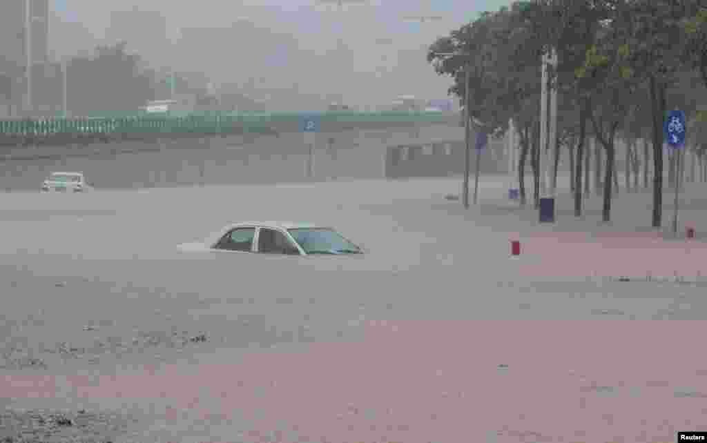 Cars are submerged in a flooded road as heavy rainfall hits Guangzhou, Guangdong province, China.